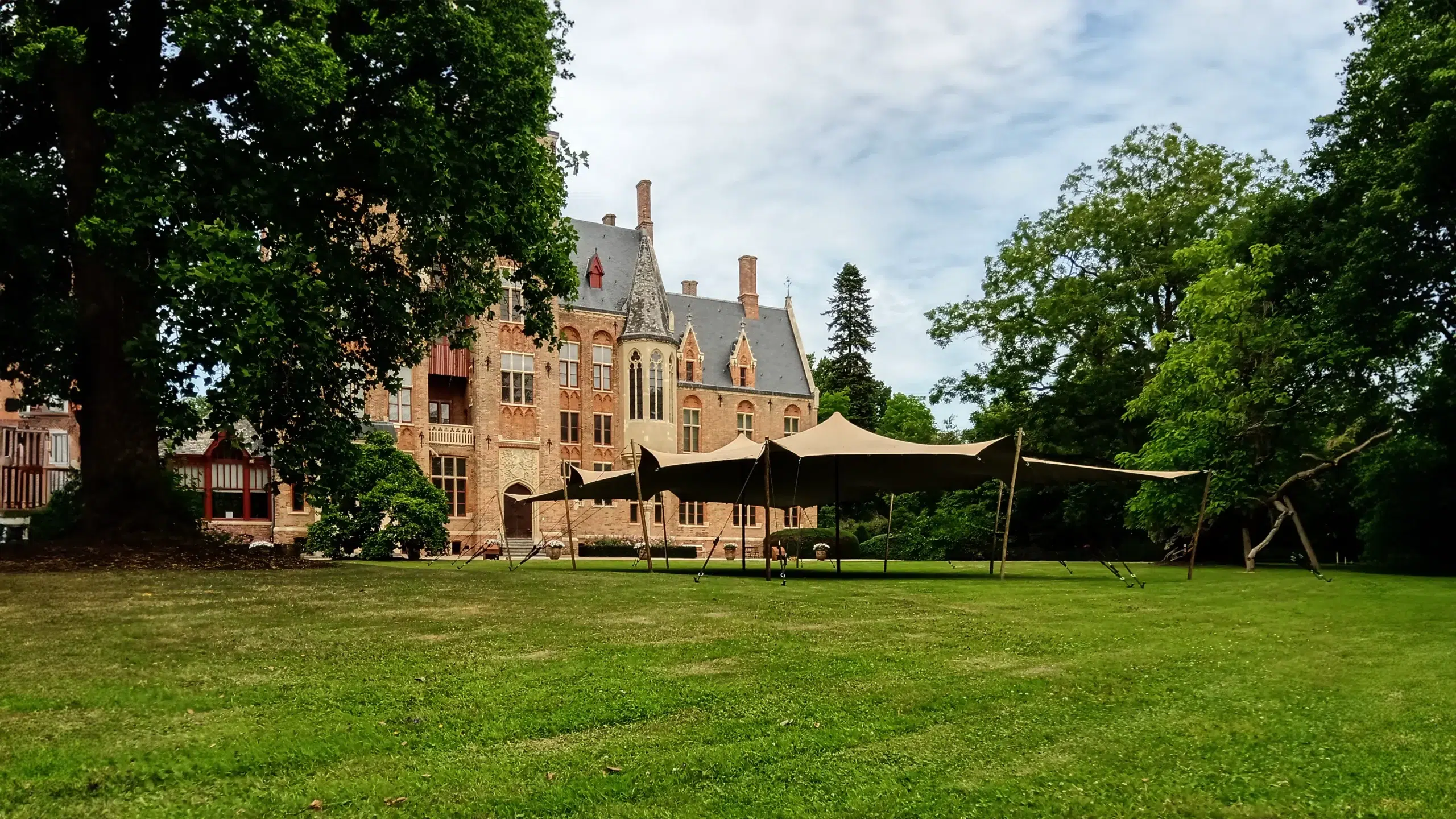 Qtents stretch tent in front of castle on a green field