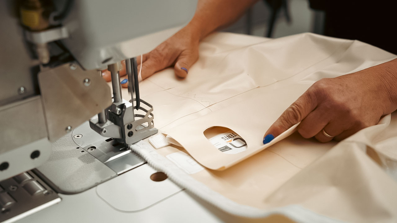 Woman sewing the sailcloth tent for qtents