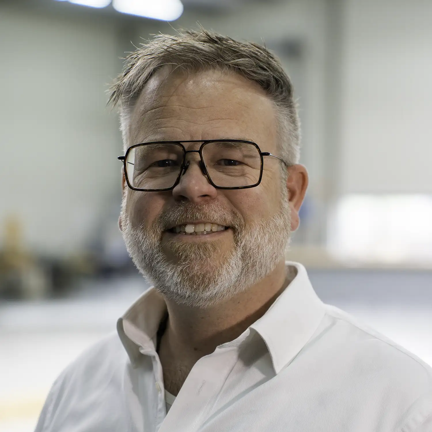 Qtents medewerker met baard en bril