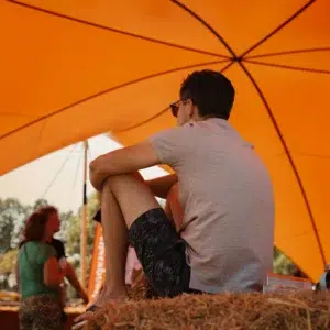 Qtents orange festival tent outdoor area with person